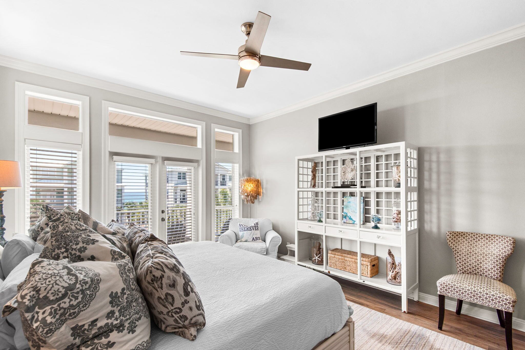 Une chambre à coucher avec un lit, une armoire blanche, un téléviseur et une chaise.