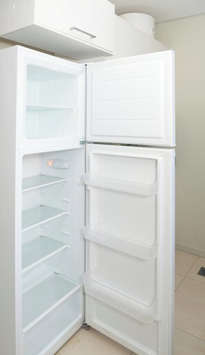 A white refrigerator with multiple shelves and a freezer compartment. - Urban One BR with Outdoor Pool, Easy City Access (Asunción)
