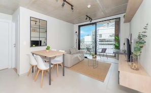 A modern apartment with a dining area, sofa, balcony, and large windows. - Modern Apt w/City View | Gym, Pool | Walk to Malls (Asunción)