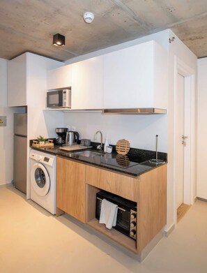 Una cocina moderna con electrodomésticos integrados, microondas, lavadora y tostadora.