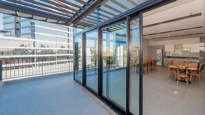Um apartamento moderno com varanda, área de refeições e cozinha.