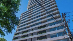 En høj, moderne bygning med en glaseingang og et skilt, der siger 'SKY TOWER'.