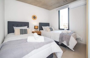 Ein Hotelzimmer mit zwei Betten, einer runden Wanddekoration, einem Nachttisch und einem Fenster.
