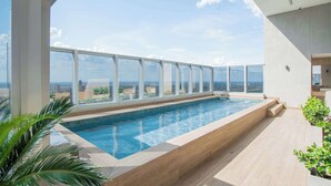 Una piscina a sfioro sul tetto con vista panoramica sulla città.