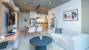 Un soggiorno moderno con divano, tavolino e zona pranzo.