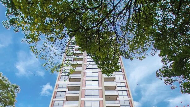 A modern building with a large entrance, a sign reading 'matrisa,' and a view of the sky. - Chic Studio Near Malls with Pool and Gym (Asunción)