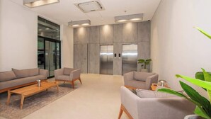 Een moderne lobby met banken, een salontafel en een lift.
