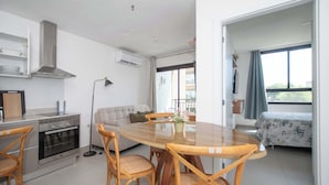 Cozinha moderna com área de jantar, um sofá e varanda com vista.