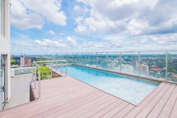 Ein Rooftop-Pool mit Infinity-Kante und freiem Blick auf die Stadtlandschaft.