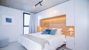Una camera da letto moderna con un letto grande, lampade da comodino, una testiera e una finestra con tende.