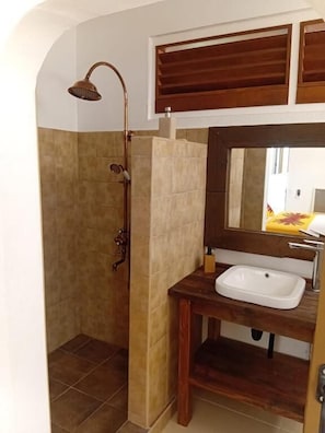 A bathroom with a shower, a sink, and a mirror. - Aremiti - Fare Orotia (Avera, Raiatea)