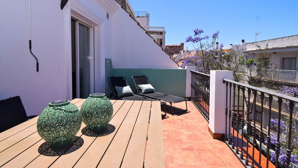 A balcony with two lounge chairs, a table, and decorative vases. - Ref: 258. Charming attic apartment in Los Boliches close to the beach (Fuengirola)