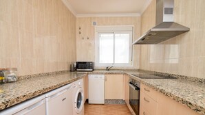 A compact kitchen with a washing machine, microwave, and a window. - Ref: 258. Charming attic apartment in Los Boliches close to the beach (Fuengirola)