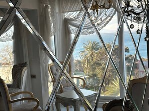 Ein Zimmer mit Meerblick, einem Chandelier und einem Tisch mit Stühlen.