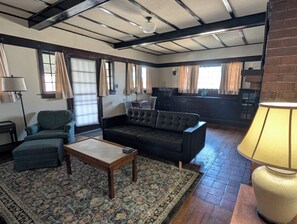A living room with a sofa, armchair, and coffee table, a patterned rug, and a fireplace. - Home in 4th & Gill Near Downtown (Knoxville)