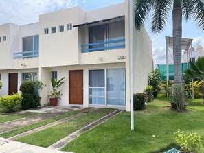 A modern two-story building with a flat roof, large windows, and a balcony with blue railings. - Casa Bahia Private Azul, Nayarit (Mezcales)