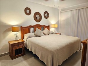 A bedroom with a wooden bed, two bedside tables with lamps, and three wall-mounted mirrors. - Casa Bahia Private Azul, Nayarit (Mezcales)