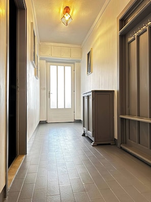Ein Flur mit Tür, Leuchte und Schrank.