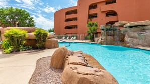 Un hotel con piscina rodeado de formaciones rocosas y vegetación.