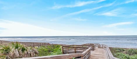 Una pasarela de madera que conduce a una playa con vistas al océano.