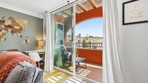 Ein Zimmer mit einer Schiebetür zum Balkon, einer Karte an der Wand und einem gerahmten Zitat.
