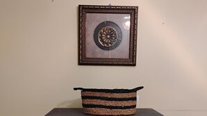 A dark wooden dresser with two drawers and a woven basket on top.