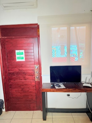 A reception desk with a television, a sign on the door, and a window with a view. - 2 minutes walk to the boardwalk and 4 to the beach (Puerto Vallarta)