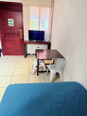 A room with a bed, a desk with a TV, and a window. - 2 minutes walk to the boardwalk and 4 to the beach (Puerto Vallarta)
