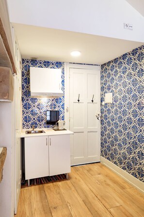 A small kitchen with a white countertop, a sink, and a white cabinet. - VIVA Porto Tile Studios 4T (Porto)
