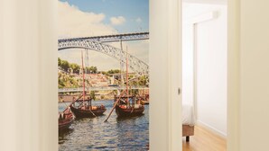 A hallway with a mural of a bridge over water, wooden flooring, and a white door. - VIVA Casa da Música Apartment (Porto)