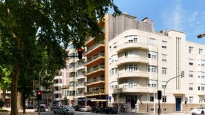 A multi-story building with balconies, a street intersection, and cars. - VIVA Casa da Música Apartment (Porto)