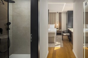 A modern hotel room with a shower, a bed, a desk, and a chair. - Heritage Hotel Ames (Poreč)