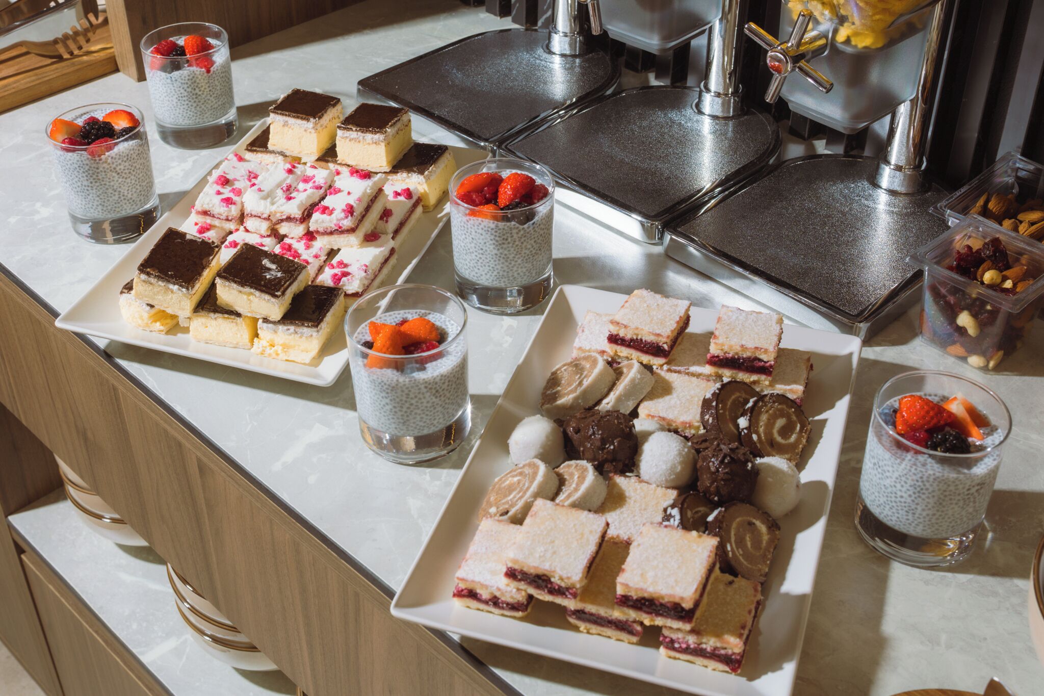 Una mesa de buffet con diversos postres y bebidas.