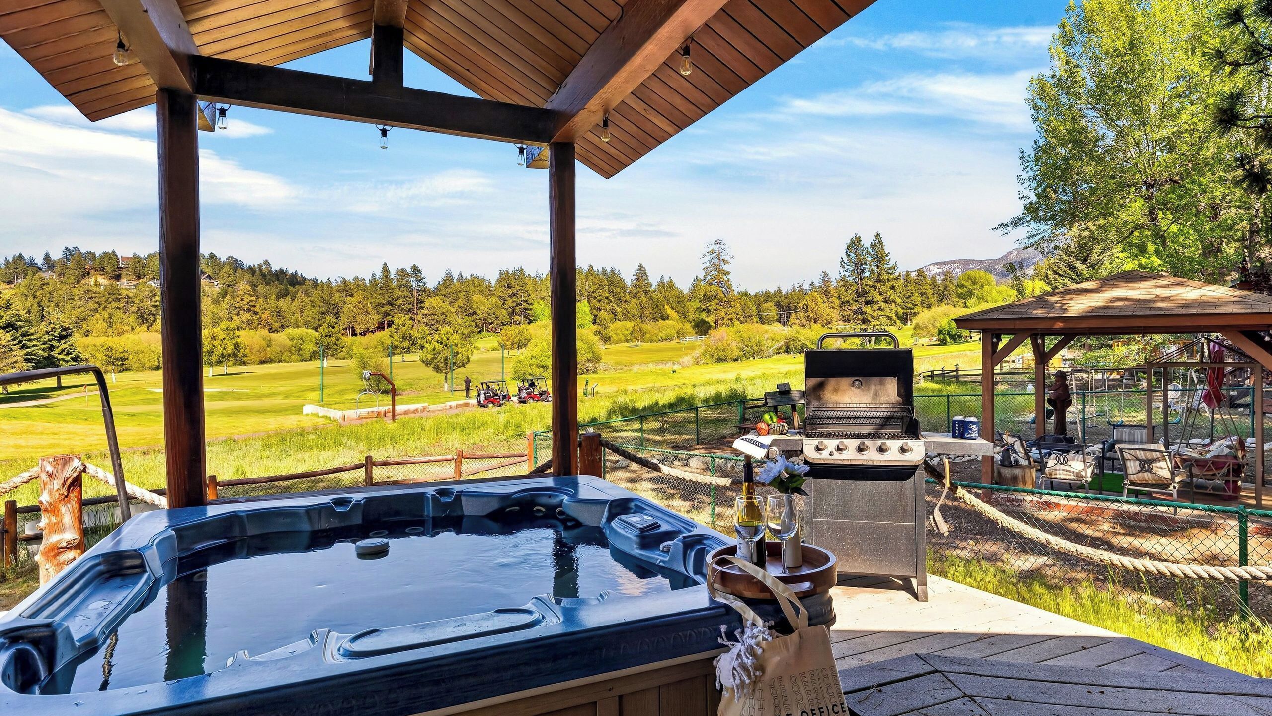 Tinaco, parrilla exterior y zona de estar con vistas a un campo de golf.