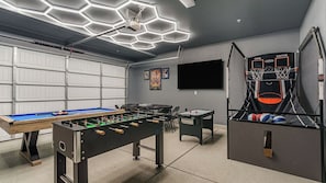 Et garage med billardbord, fodboldbord og basketballkurv.