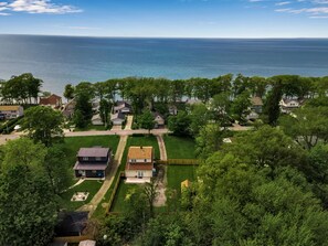 A residential area with houses, a green lawn, and a view of the sea. - Updated 3 bedroom Lake Erie cottage steps from the water (Angola)