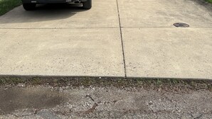Uma casa moderna de dois andares com garagem, um SUV branco estacionado em frente e céu claro.