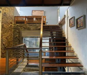 A staircase with wooden steps and metal railings, leading to an upper level. - Cozzy Pondok Sukamulus (Bandung Barat)