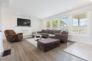 A modern living room with a sectional sofa, a recliner, a glass coffee table, and a fireplace. - Private room in ottawa (Ottawa)