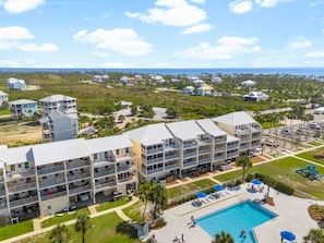 Ein mehrstöckiges Hotel mit Balkonen, einem Schwimmbad und Blick aufs Meer.
