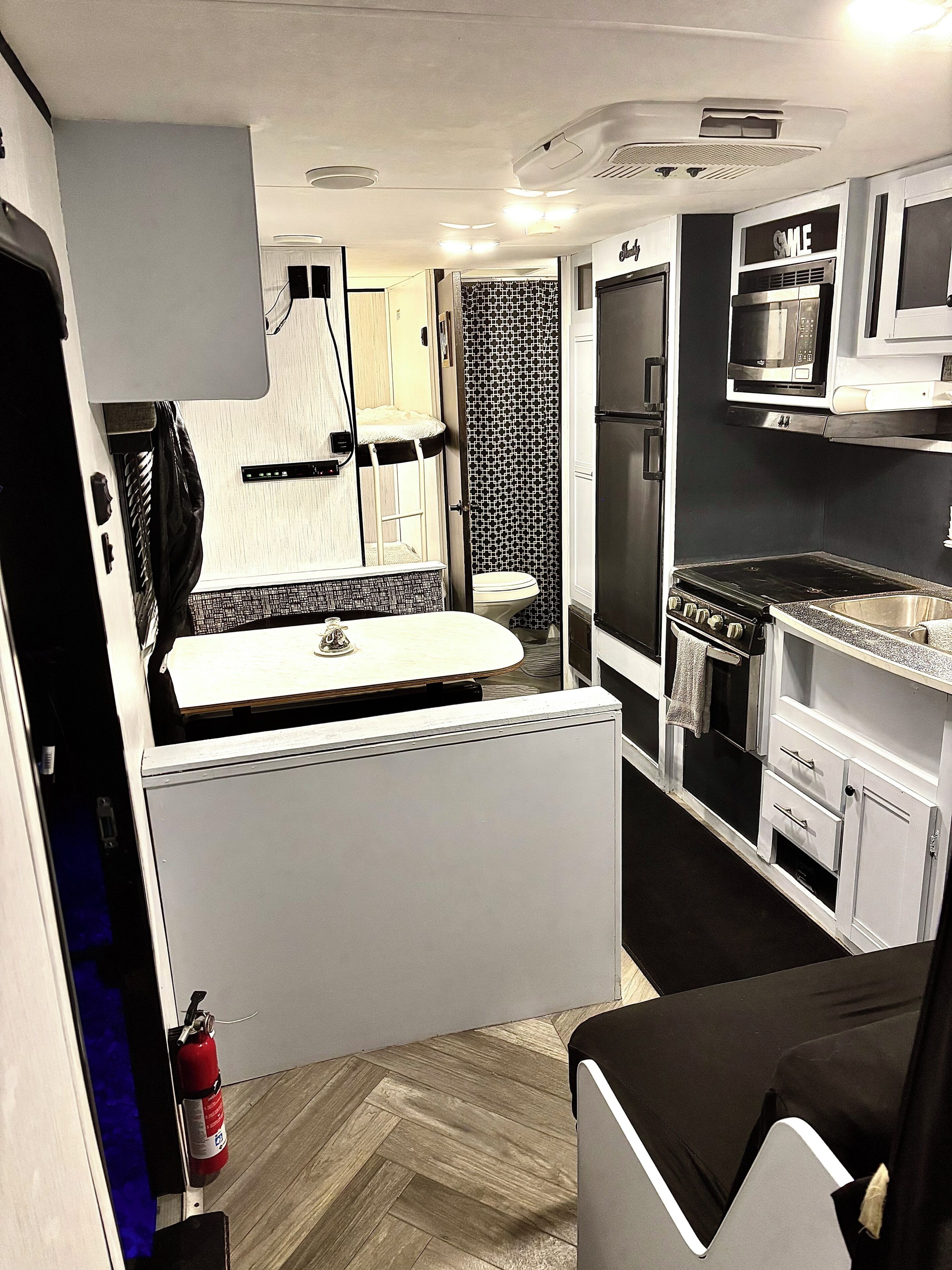 Una piccola cucina accessoriata con microonde, fornello e lavello.