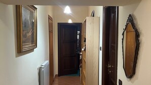 A hallway with a radiator, a door, and a framed picture on the wall.