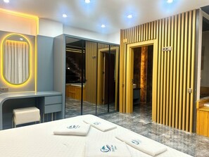 A modern hotel room with a large bed, a desk, a vanity, and a view of the city at night. - ELITE Delphin Villas Kalkan, Luxurious, private pool, sea view 4+1 (Kas/Kalkan)