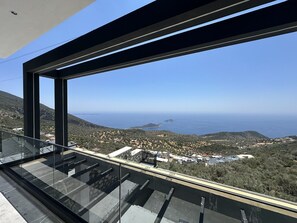 A modern building with a large glass balcony overlooking a coastal landscape. - ELITE Delphin Villas Kalkan, Luxurious, private pool, sea view 4+1 (Kas/Kalkan)
