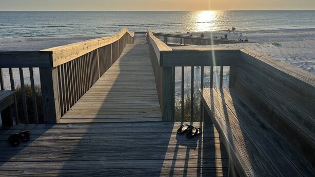 A wooden boardwalk leading to the beach with a sunset in the background. - St. Somewhere in Seacliffs (Port St. Joe)