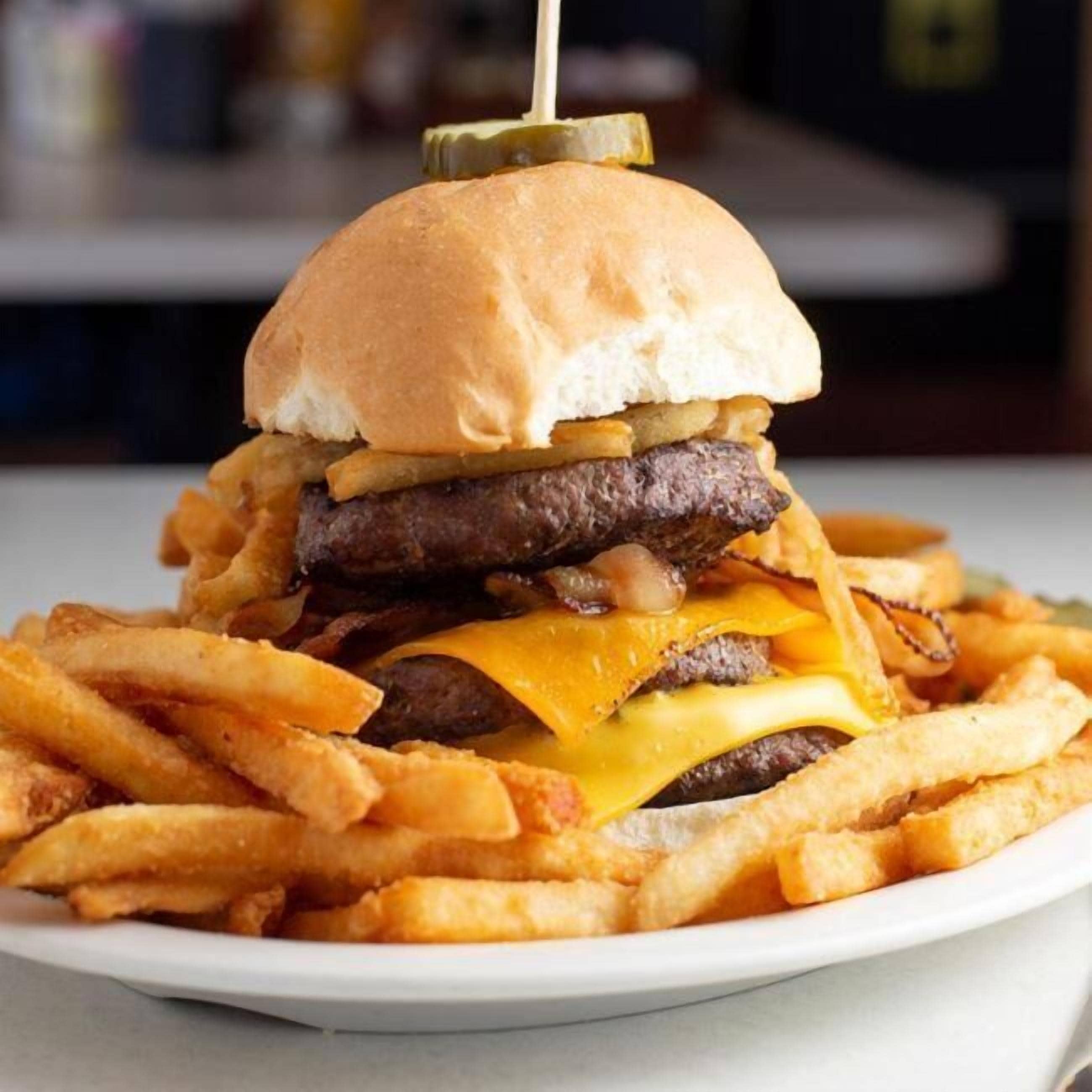 Un hamburger con patatine fritte su un piatto.