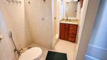 Ein Badezimmer mit Dusche, Toilette und Waschbecken.