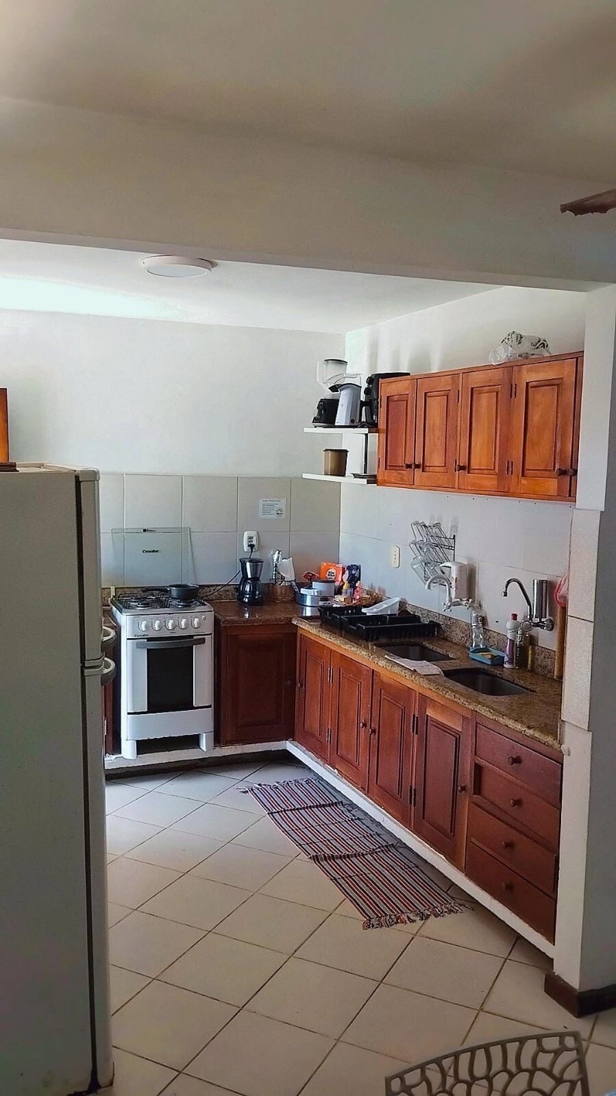 Una cocina compacta con estufa, lavamanos y armarios de madera.