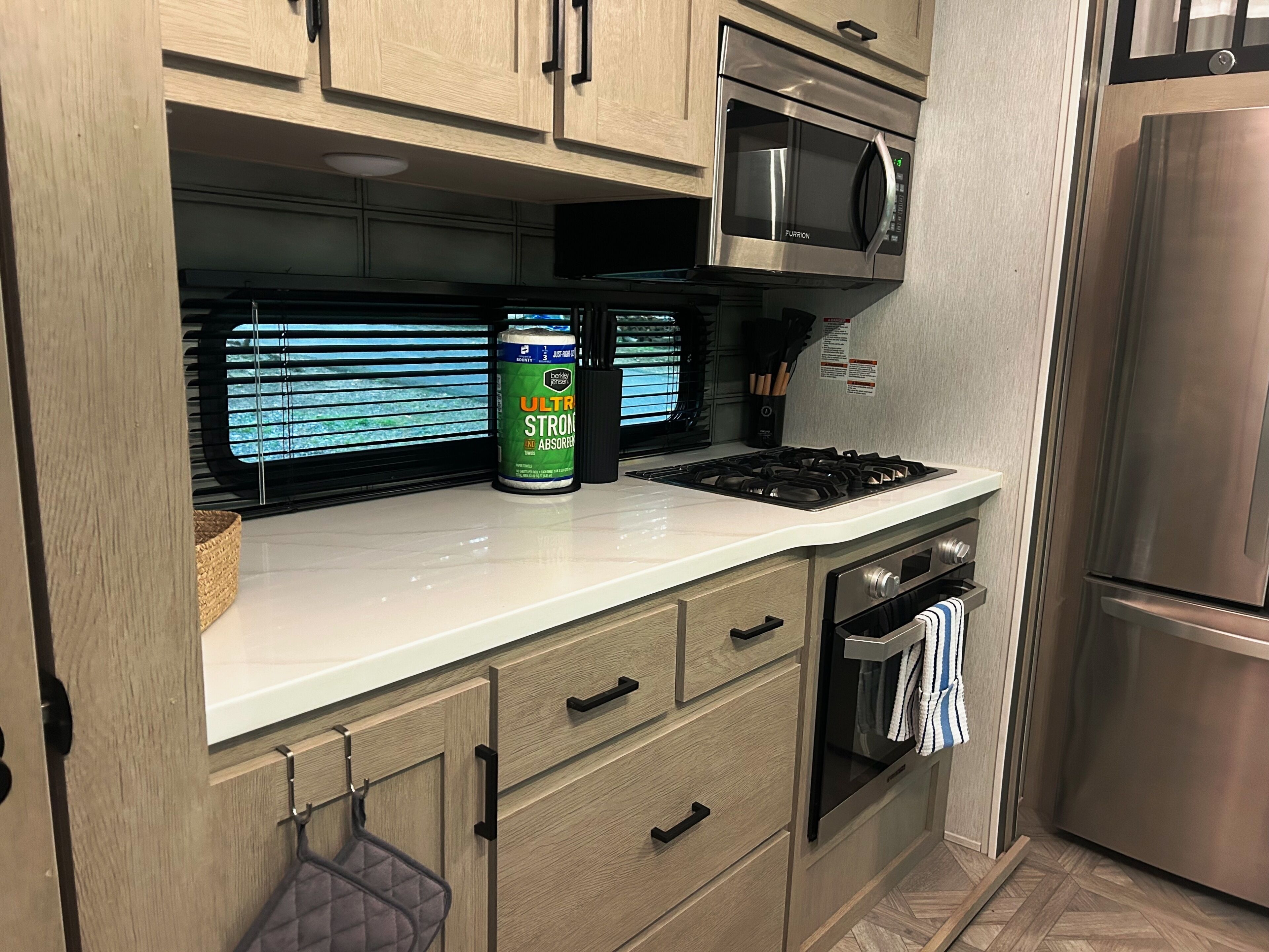 Una cocina con microondas, estufa y refrigerador de acero inoxidable.