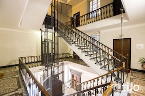 A multi-level interior with a grand staircase, multiple doors, and a chandelier. - Train Station| 3BR| A/C| City Center By Tilo (Genova)